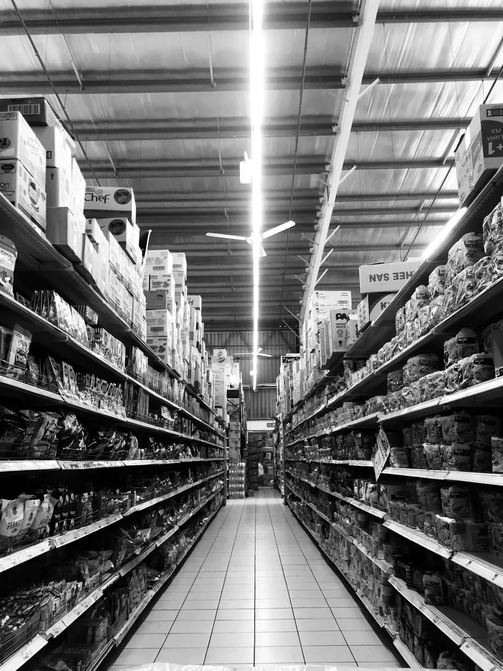 Corredor de supermercado com prateleiras organizadas e produtos — controle de estoque na loja